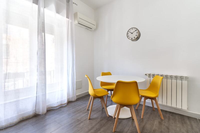 Tavolo rotondo bianco con quattro sedie gialle